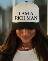 Person wearing a cap with 'I AM A RICH MAN' text