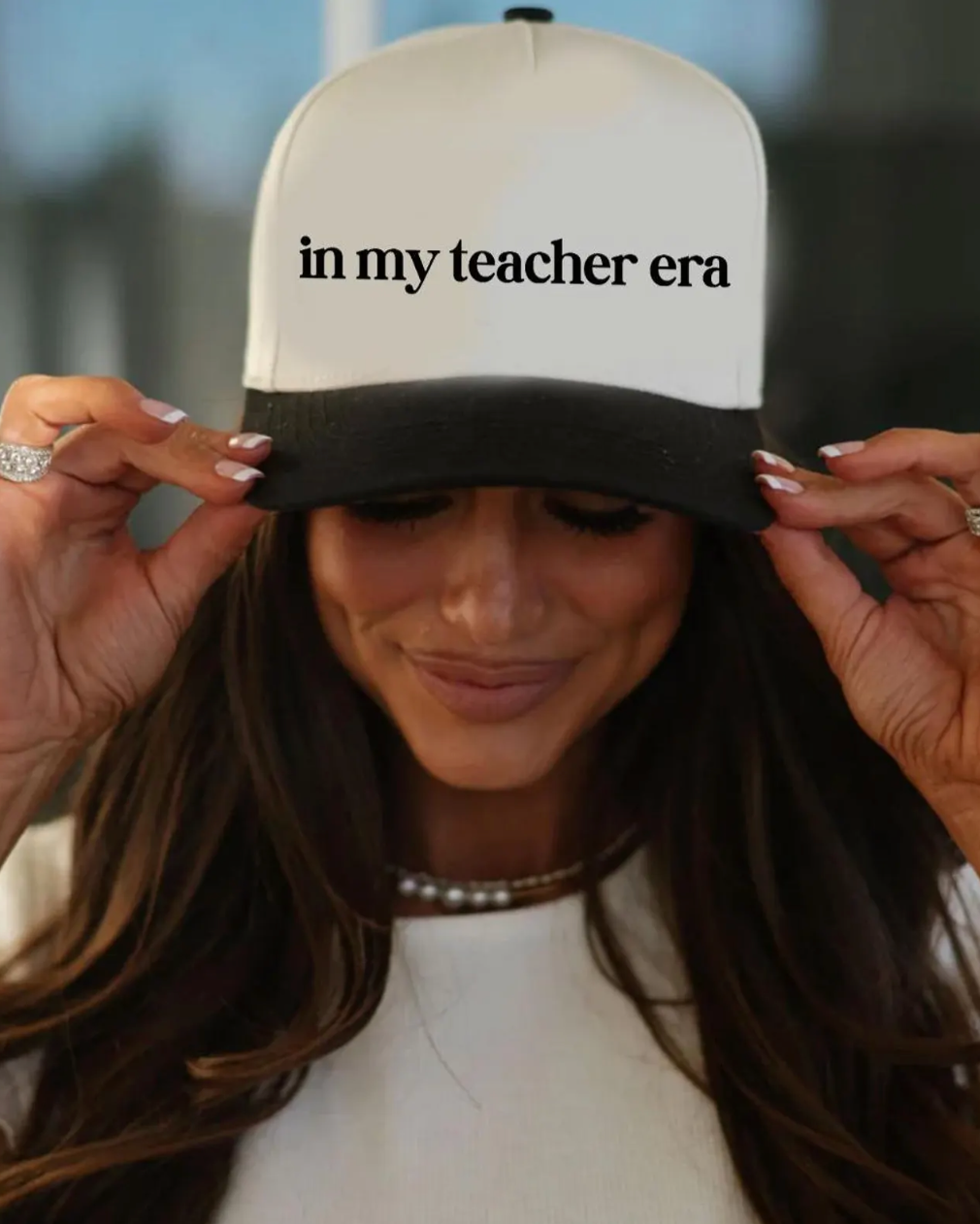 Person wearing a cap with 'in my teacher era' text